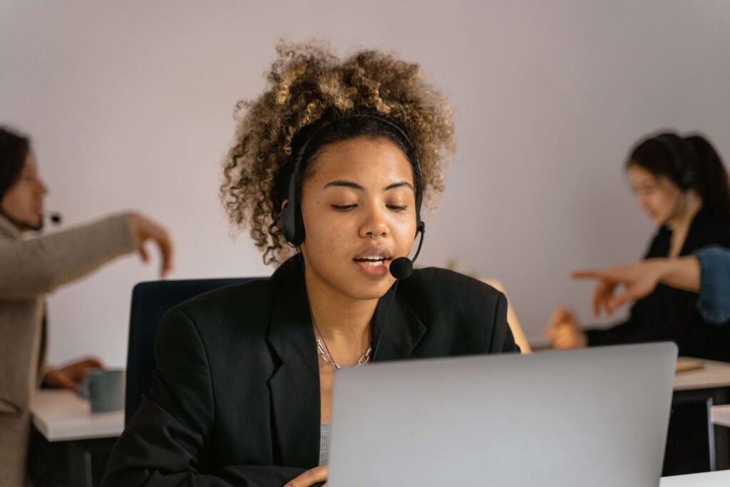 Appointment Setter wearing a headset while assisting customers on a laptop in a remote work environment